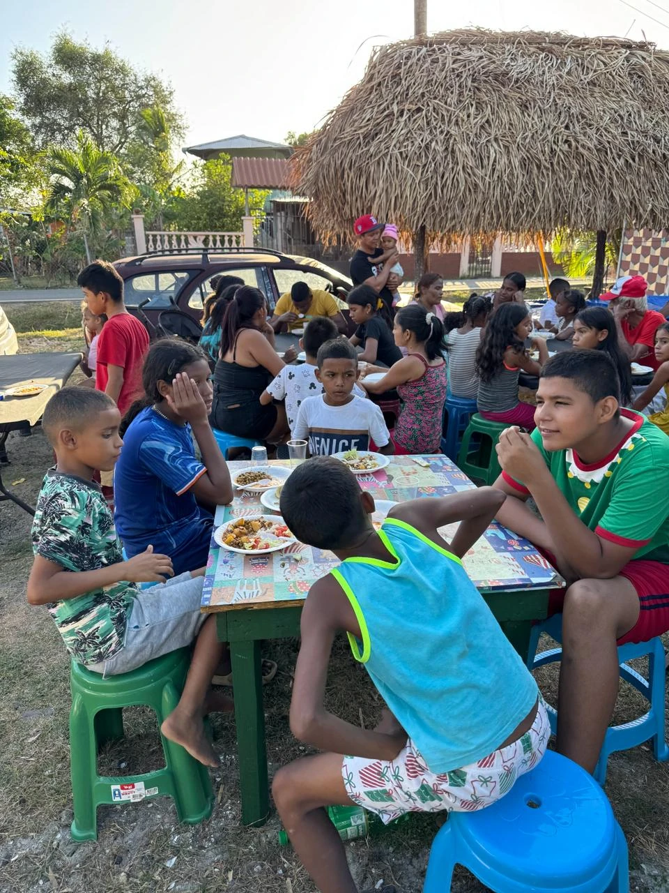Children sitting together at a table, eating hot meals